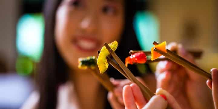 asiatisk flicka äter med innar