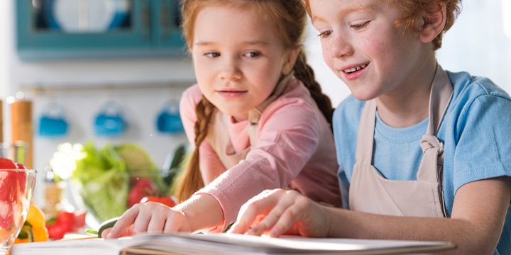 Kokböcker: 2 barn i köket med en kokbok