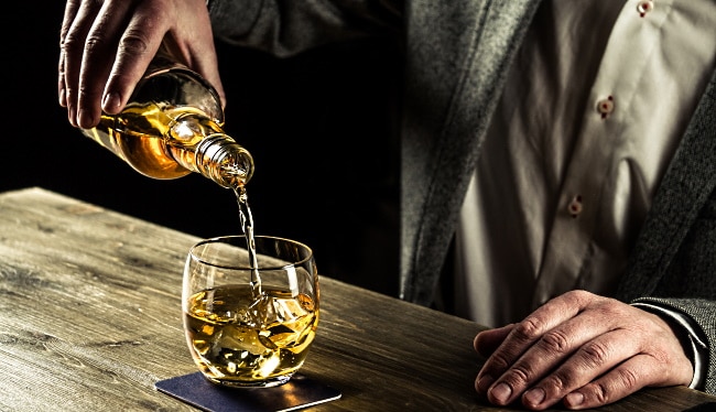 Japansk whisky - en man som häller upp whisky ur en flaska